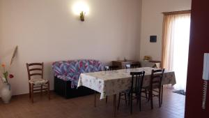 Etna Sun Guest House في ماسكالي: غرفة طعام مع طاولة وكراسي