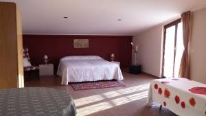 マスカリにあるEtna Sun Guest Houseの白いベッドと赤い壁が備わるベッドルーム1室が備わります。