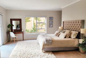 een slaapkamer met een groot bed en een raam bij Easy living West Beach family home in Kaapstad