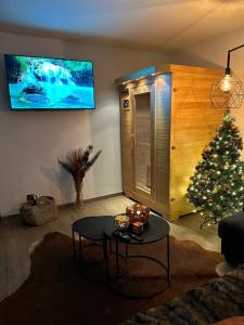 a living room with a christmas tree and a tv at Suite Tino - Jacuzzi privé, cabine infrarouge & vue in Verviers
