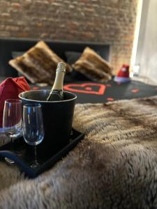 a bottle of champagne in a bucket next to two glasses at Suite Tino in Verviers