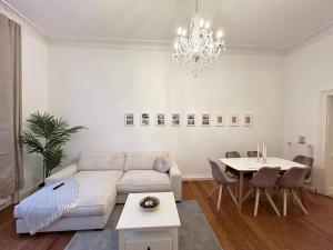 a living room with a couch and a table at IDEE Living: Traumhaftes Altbau Apartment - Balkon in Wiesbaden