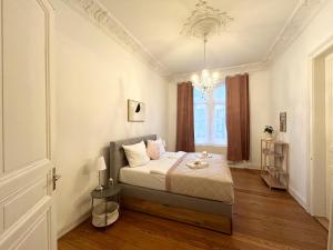 een slaapkamer met een bed en een kroonluchter bij IDEE Living: Traumhaftes Altbau Apartment - Balkon in Wiesbaden