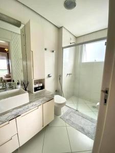 y baño con aseo y ducha. en Apartamento aconchegante em Floripa - caminho das praias, en Florianópolis