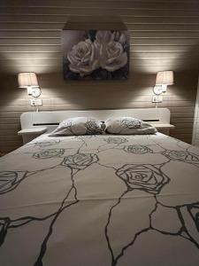 a bedroom with a large bed with two lamps on it at Le Colibri spa jacuzzi in Durbuy