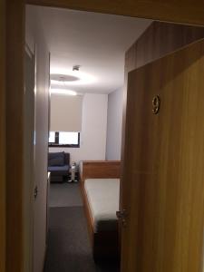 a small room with a bed and a door at PAHULJA Apartman Kopaonik Brzeće in Brzeće