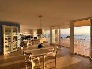uma sala de jantar com uma mesa e vista para o oceano em Villa Sa Calma em Begur