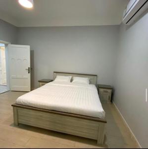 a bed in a room with a white wall at فيلا 109 الطائف الشفا in Al Shafa