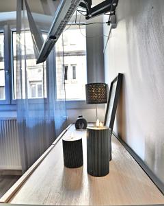twee kaarsen op een tafel in een kamer met een raam bij Dolce Vita - Hypercentre - TV 4K - Fibre - Netflix in Saintes