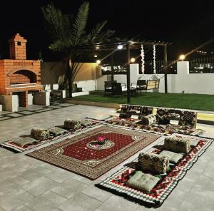 um pátio com um tapete com almofadas em فيلا 109 الطائف الشفا em Al Shafa