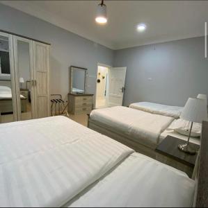 a hotel room with two beds and a television at فيلا 109 الطائف الشفا in Al Shafa