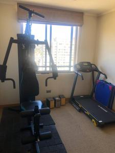 a room with a gym with a treadmill and a window at Espectacular departamento in Viña del Mar