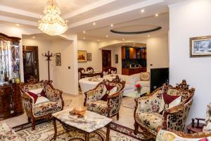 Spacious City Paradise - 3BR Apt in the Heart of Tirana في تيرانا: غرفة معيشة مع كراسي وحوض استحمام