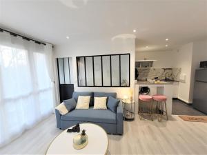 sala de estar con sofá azul y mesa en Splendide Appartement Proche Paris & Orly, en Chevilly-Larue