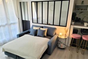sala de estar con sofá azul y ventana en Splendide Appartement Proche Paris & Orly, en Chevilly-Larue