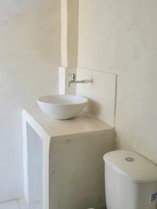 a white bathroom with a sink and a toilet at Apartaestudio en la Montaña de Taganga in Santa Marta