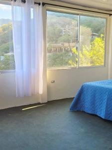 a bedroom with a bed and a large window at Apartaestudio en la Montaña de Taganga in Santa Marta +6 photos