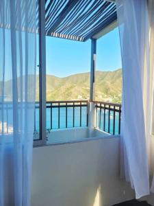 a balcony with a large window with a view of the mountains at Apartaestudio en la Montaña de Taganga in Santa Marta