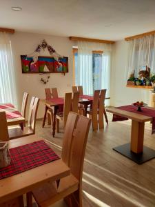 uma sala de jantar com mesas e cadeiras de madeira em Agritur Maso Flonkeri em Bosentino