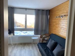 a living room with a couch and a window at Studio Puy Saint Vincent 1600 aux pieds des pistes in Puy-Saint-Vincent