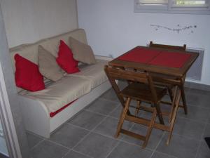 um sofá com almofadas vermelhas ao lado de uma mesa em Maison Halle em Pouxeux