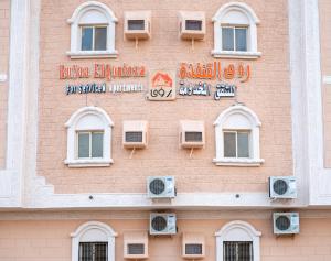 um edifício com placas na lateral em Ru'a Al Qunfudhah Furnished Units em Al Qunfudhah