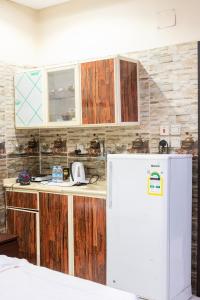 a kitchen with wooden cabinets and a white refrigerator at Ru'a Al Qunfudhah Furnished Units in Al Qunfudhah