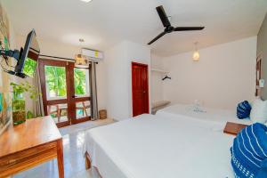 1 dormitorio con 2 camas blancas y ventana en Hotel San Vicente en Playa del Carmen