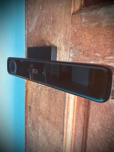 un celular saliendo de una puerta de madera en Junest Hut en Pantai Cenang