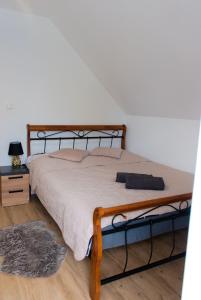- une chambre avec un lit doté d'un cadre en bois dans l'établissement Apartament Pod Brzyzkiem, à Leśnica