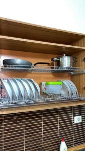 un estante de cocina con platos y utensilios. en Budget Beach Apartment 35% Discount, en Durrës