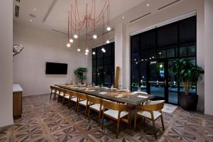 a large dining room with a long table and chairs at NOUN Hotel, Norman, a Tribute Portfolio Hotel in Norman