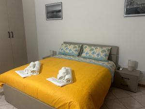 a bedroom with a yellow bed with towels on it at Seaview in Salerno