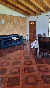 a living room with a couch and a wooden floor at Casa de campo in Villarrica +5 photos