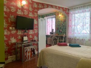 a bedroom with red walls and a tv on the wall at Podil Apart Сковороди Kontraktova Ploscha in Kyiv