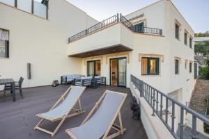 a deck with two lounge chairs and tables on it at Bello Horizonte in Altea