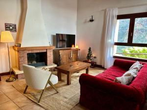 uma sala de estar com um sofá vermelho e uma lareira em Casa Guergue by VV Canary Ocean Homes em Masca