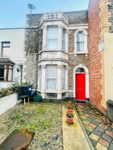 an old brick house with a red door at Mia Property - Two Mile Hill in Bristol