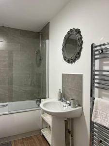 a bathroom with a sink and a shower and a mirror at Modern Relaxing Apartment in Stoke on Trent