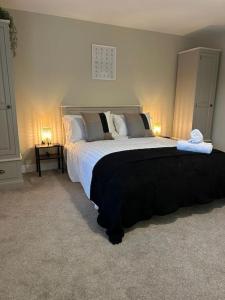 Modern Relaxing Apartment في ستوك أون ترينت: غرفة نوم بسرير كبير فيها مصباحين