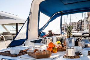 a table on a boat with food on it at Barca a vela Kerama - Smart Wind in Naples