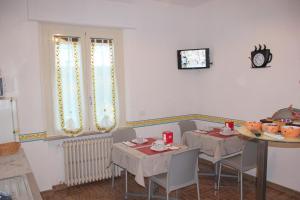 una sala da pranzo con due tavoli e un tavolo con sedie di B&B Panorama d'Assisi a Santa Maria degli Angeli