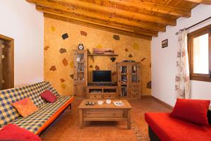 Una sala de estar con un sofá y un televisor. en Casa Rural Tadia, en San Bartolomé