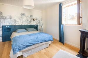 - une chambre avec un lit bleu et une fenêtre dans l'établissement PARLEMENT 2 - 55m2 -2 CH et 2 SDE, à Rennes