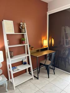 a room with a desk and a ladder next to a table at L’Appart - Les pieds dans l’eau in Sainte-Luce