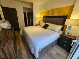 1 dormitorio con 1 cama grande con colcha blanca en Torre Pamplona 102-Nuevo y Céntrico-Apartamento en Guatemala