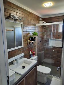 ein Badezimmer mit einem Waschbecken, einem WC und einem Spiegel in der Unterkunft Rota Beach-Aeroporto l ortobom queen l ar cond l tv smart l wi-fi l cozinha completa in Maceió