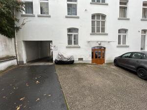 un'auto parcheggiata di fronte a un edificio bianco di IDEE Living: Traumhaftes Altbau Apartment - Balkon a Wiesbaden