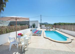 eine Terrasse mit einem Tisch, Stühlen und einem Pool in der Unterkunft Owl Booking Villa Trinxater - 12 Min Walk to the Beach in Alcúdia