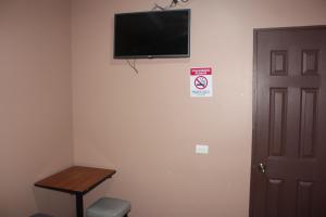 a room with a flat screen tv on a wall at Hotel Pecos Bill in San José